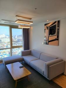 丽水市Hotel Kenny Yeosu的客厅配有沙发和桌子