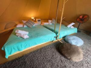 佩纳利克村Rembulan Escape - beachfront bell tent (no 2)的帐篷内的两张床和枕头