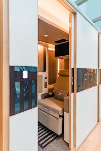 迪拜sleep 'n fly Sleep Lounge & Showers, B-Gates Terminal 3 - TRANSIT ONLY的享有带沙发和电视的客厅的景色。