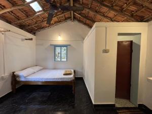 戈卡尔纳HostelExp, Gokarna - A Slow-Paced Backpackers Community的一间带一张床铺的卧室,位于带天花板的房间内