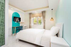 头顿Sunset Bãi Dâu Boutique Hotel Vũng Tàu的卧室配有白色的床和窗户。