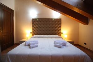 布吕松Attico dell'Aquila的卧室配有一张带两个枕头的大白色床