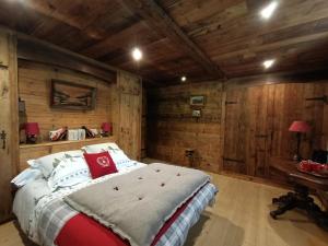 瓦什雷斯La montagnarde des Sapins Blancs的卧室配有一张床铺,位于带木墙的房间内