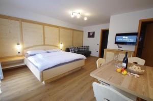 奥蒂塞伊呼柏图斯维拉公寓式酒店的一间卧室配有一张床和一张桌子及一台电视
