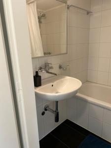 苏黎世Guesthouse Elisa 6的白色的浴室设有水槽和浴缸。