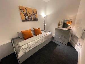 伯明翰Urban 3 Bedroom Home in Kings Heath-Great Location的一间卧室配有带橙色枕头的床