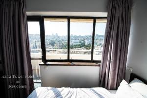 海法Haifa Tower Hotel - מלון מגדל חיפה的一间卧室设有一张床和一个大窗户