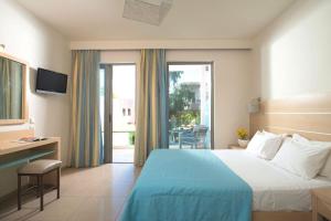 耶奥伊乌波利斯Corissia Beach hotel的配有一张床、一张书桌和一扇窗户的酒店客房