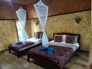 瑶亚岛活动度假村的一间卧室配有两张床、窗帘和长凳