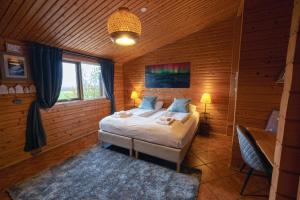 劳加尔瓦特恩艾弗斯达勒农场酒店的木制客房内的一间卧室,配有一张床