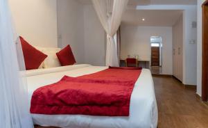 奈瓦沙伯奇奈瓦沙度假村的卧室配有一张大白色床和红色毯子