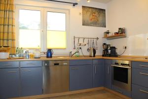 卢布明Ferienwohnung Schwanenwiek的厨房配有蓝色橱柜和台面