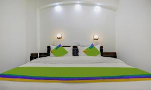 古尔冈Treebo Trend Amexx Golf Course Road的一间卧室配有一张绿色和紫色的白色床
