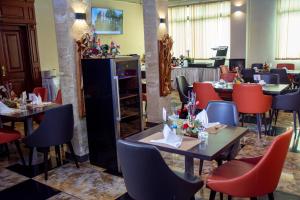 雅温得New Heaven Hôtel的用餐室配有桌子和红色椅子