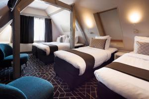 阿姆斯特丹CC酒店的酒店客房,设有三张床和椅子