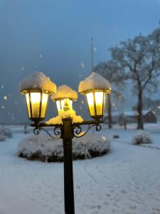 摩尔比兰加Hotell Magasin 1的雪覆盖着的街道灯,有两盏灯