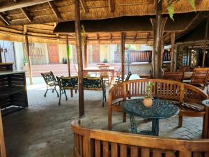 约翰内斯堡Goodnight Guest Lodge的餐厅设有木桌、椅子和桌子