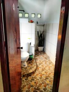 武吉拉旺Sumatra Orangutan Discovery Villa的一间带卫生间的浴室和瓷砖地板。