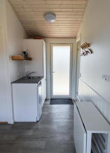 亨讷斯特兰德BLÅBJERGGAARD - Hennebysvej 60的厨房配有白色冰箱和门