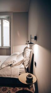 巴勒莫Casa 3D'Oro Palermo的一间卧室配有一张床、一张桌子和一个窗户。
