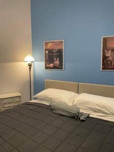 巴韦诺B&B Gloria Apartment的一间卧室设有两张床和蓝色的墙壁