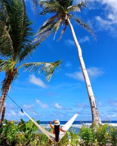 San IsidroBamboo Surf Beach的躺在两棵棕榈树下吊床上的人