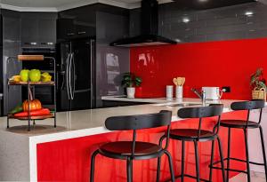 贝尔拉拉古木斯安克雷奇酒店的厨房设有红色和黑色的墙壁和酒吧凳子