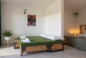 沃尔沃罗西蒙王子普莱乌公寓式酒店的一间卧室配有一张绿色的床和一张床