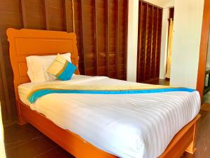 NakasongNakasang Paradise Hotel的一间卧室配有带白色床单和枕头的床。