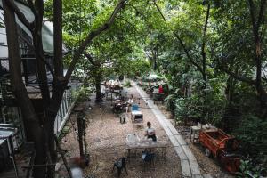 曼谷The Yard Bangkok Hostel的一群坐在花园里桌子上的人