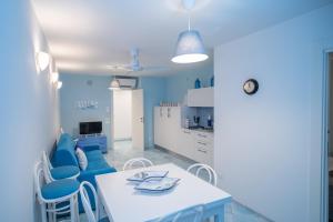 切塔拉Casa Azzurra的厨房配有白色的桌子和蓝色的椅子