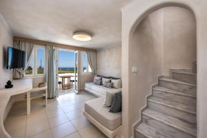 卡特瑞杜斯Aelia Luxury Suites的客厅设有楼梯,通往一间享有海景的房间