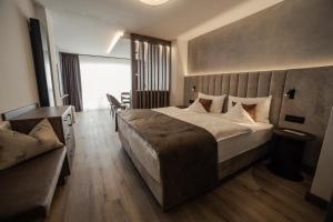 塞尔瓦迪加尔代纳山谷Freina Mountain Lifestyle Hotel的一间卧室配有一张大床和一张沙发