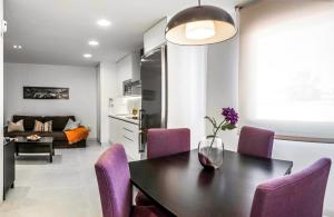 萨阿拉德洛斯阿图内斯Apartamentos Levante的厨房以及带桌子和紫色椅子的用餐室