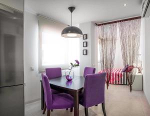 萨阿拉德洛斯阿图内斯Apartamentos Levante的一间用餐室,配有紫色椅子和一张桌子