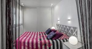 萨阿拉德洛斯阿图内斯Apartamentos Levante的一间卧室配有一张带粉红色和紫色毯子的床