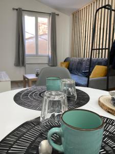 马诺斯克Appartement loft Manosque的上面有杯子和盘子的桌子