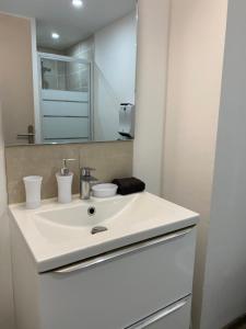 马诺斯克Appartement loft Manosque的浴室设有白色水槽和镜子