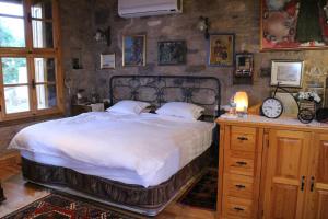 艾瓦勒克Stone House with Garden in Cunda/Ayvalik的一间卧室配有一张大床和一张带时钟的桌子