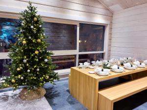 罗瓦涅米Santa's Luxury Boutique Villa, Santa Claus Village, Apt 2的一间桌子的房间中间的圣诞树