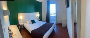 图卢兹美国酒店的一间卧室设有一张床和绿色的墙壁