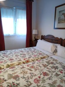 科伦加Hotel Los Caspios的一间卧室配有一张带花卉床罩的床