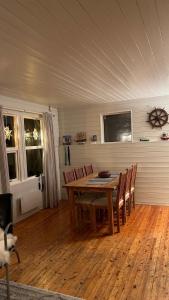 特罗姆瑟Cozy little house in Tromsø city的一间带木桌和椅子的用餐室