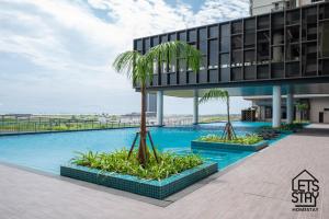 马六甲Bali Premier Suites Melaka的享有带棕榈树游泳池的建筑的景致