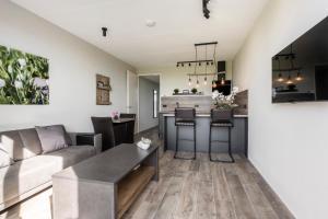 诺德韦克Holiday Apartment Duin的厨房以及带沙发和桌子的客厅。