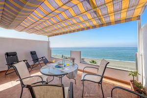 托雷德本纳贾尔邦WintowinRentals Amazing Front Sea View & Relax的一间带桌椅的海景用餐室