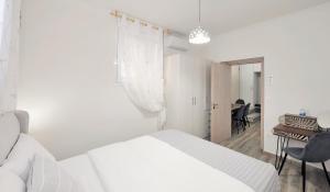 雅典Bella Ciao Guest House的白色卧室配有床和书桌