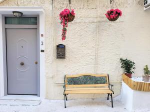 雅典Bella Ciao Guest House的木凳坐在大楼前,有一扇门