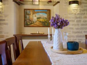 阿斯特里昂Family-Friendly Villa Erofili with Pool, Childrens Area & BBQ!的一张桌子上放着紫色花瓶