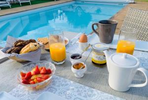 LoixClos des marais的一张桌子,旁边是游泳池,提供早餐食品和饮料